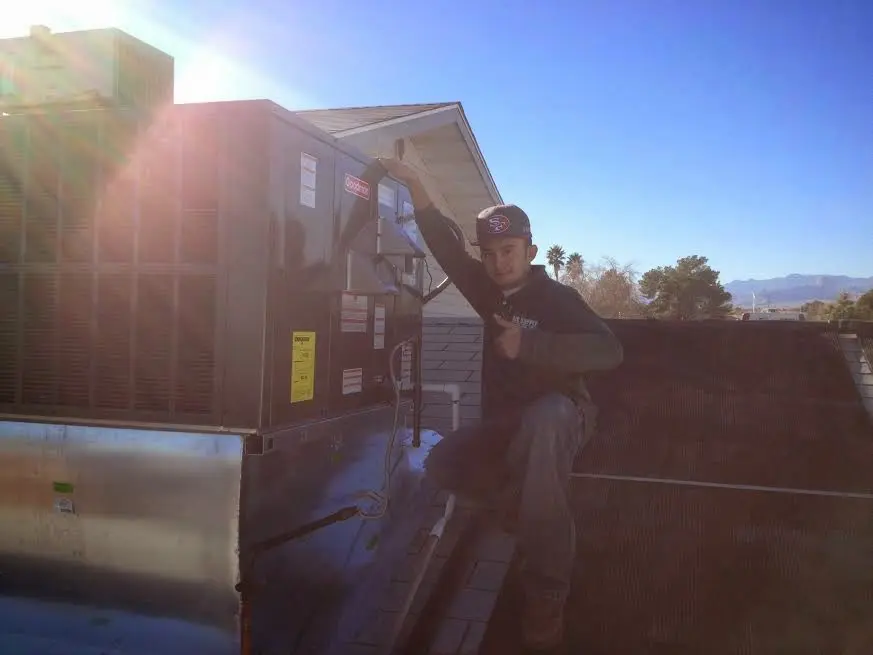 HVAC technician performing AC Tune-Up on a rooftop unit in North Springfield